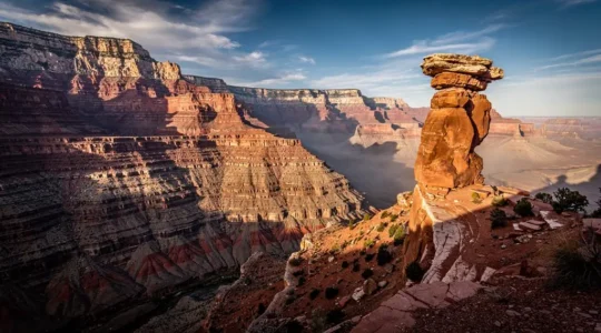 Vue panoramique sur le plateau du Colorado montrant le contraste entre un grand canyon stratifié et un amphithéâtre rocheux.